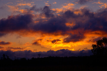 A beautiful summer sunrise in rural Latvia. Bright morning sky with dark foreground.