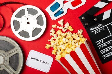 Tasty popcorn in buckets and cold cola drinks with cinema tickets, movie clapper and 3D eyeglasses...