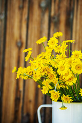 Yellow daisy flowers bouquet. Rustic background.