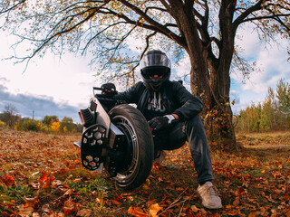 A man in a helmet is holding a monocycle. Electric monowheel is a modern urban transport. Riding in the autumn park © pavelkant