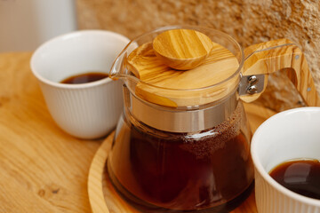 A coffee pot and mugs set the scene for a cozy morning with the inviting aroma of fresh coffee and warm vibes