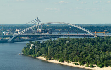 Big bridge on the river and forest on the background of the sky