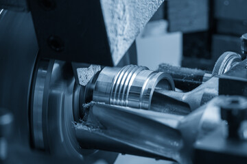 The  multi tasking CNC lathe machine thread  cutting the metal shaft parts.