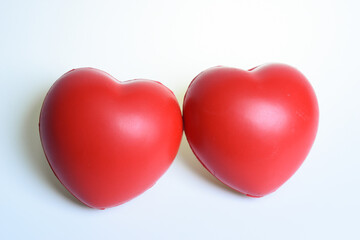 two red stress ball isolated on white background, heart shape toy