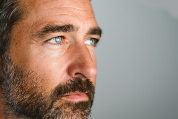 Portrait of a mature man with gray hair and blue eyes, highlighting skincare and facial grooming