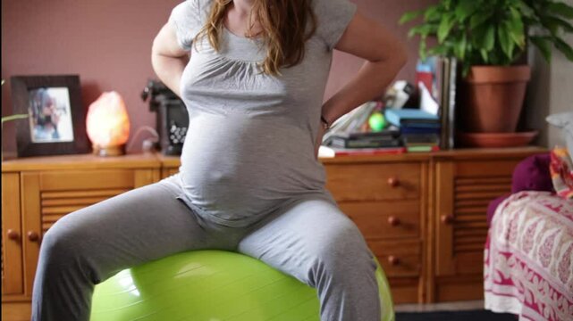Mujer embarazada en bola de yoga