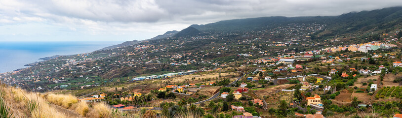 Panoramic view of the houses and villages of the island of La Palma at the foot of the volcanic mountains, Canary Islands.