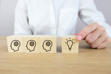 Conceptual image of vision and idea. Wooden cube blocks with head and light bulb symbols