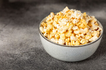 Tasty popcorn on wooden background. Cinema and entertainment concept. Movie night with popcorn.Cheese and caramel popcorn. Delicious appetizer, snack. Place for text. Copy space.Banner