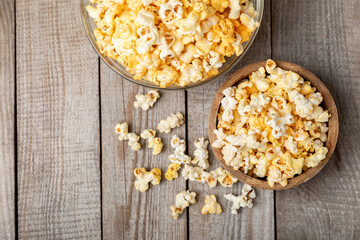 Tasty popcorn on wooden background. Cinema and entertainment concept. Movie night with popcorn.Cheese and caramel popcorn. Delicious appetizer, snack. Place for text. Copy space.Banner