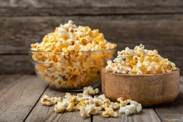 Tasty popcorn on wooden background. Cinema and entertainment concept. Movie night with popcorn.Cheese and caramel popcorn. Delicious appetizer, snack. Place for text. Copy space.Banner