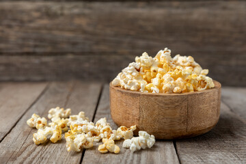 Tasty popcorn on wooden background. Cinema and entertainment concept. Movie night with popcorn.Cheese and caramel popcorn. Delicious appetizer, snack. Place for text. Copy space.Banner