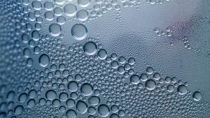 Many silver bubbles in water close up on a blue background. Background for banner, background or texture for 3D mapping, oil, water, air bubbles