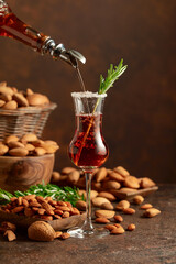 Italian liqueur Amaretto with almonds nuts on a wintage table.