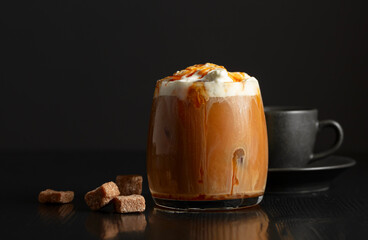 Iced coffee with whipped cream and caramel sauce and cup of black coffee.