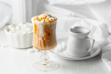 Iced caramel latte topped with whipped cream and caramel sauce.