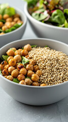 Quinoa and roasted chickpeas in separate bowls, gourmet salad ingredients, proteinpacked and wholesome