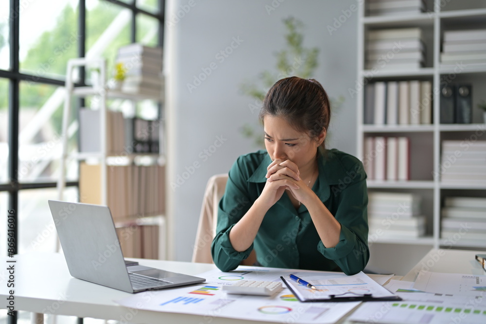 Poster businesswoman holding hands on chin, feeling tired and stressed from working on a laptop, having a h