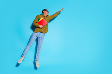 Full body photo of attractive young man hold copybooks hang empty space dressed stylish plaid clothes isolated on blue color background