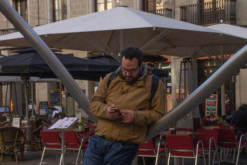 Man looks at his cell phone while waiting in the city