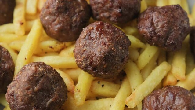 Beef meatballs and french fries. Fast food. Rotating video