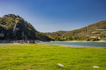 A view of Lake Turano, in the village of Castel di Tora, Rieti, Lazio, Italy. Mount Antuni, with its uninhabited village, stands in the center of the lake, surrounded by green mountains.