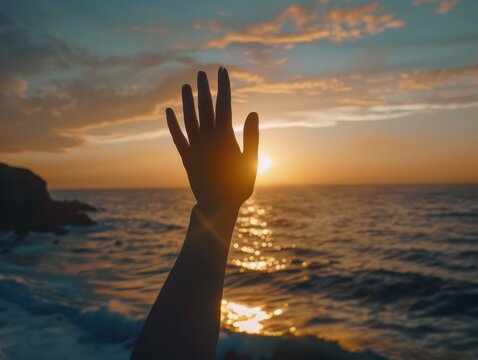 Hand in motion, waving farewell with delicate gestures, silhouetted against a serene ocean sunset, soft waves in the background