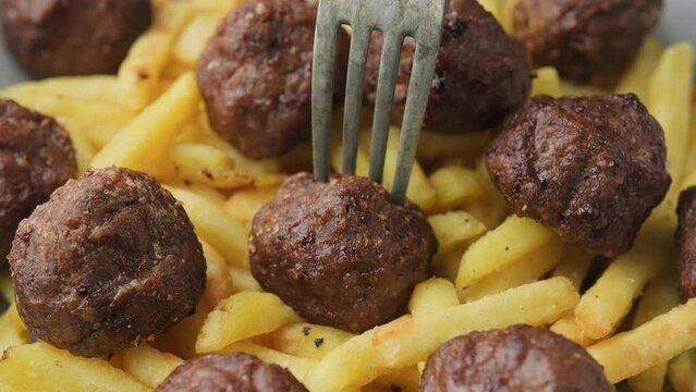 Eating Beef meatballs and french fries. Fast food