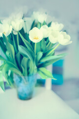 A pale photo with white tulips in a vase. very soft focus pale pastel colors. As an option for the interior, a poster.