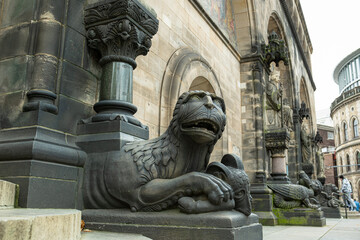 A decorative monster made of stone guards the entrance to an ancient medieval Catholic cathedral....