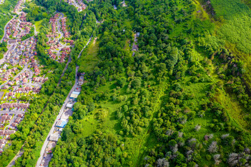 Top down aerial view of roads, houses and trees in a lush, green valley