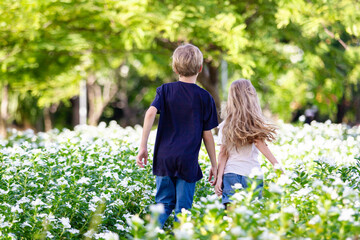 Fototapeta premium Caucasian white siblings playing at the park in morning.