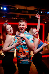 Party and celebration. Group of happy smiling friends having fun together, singing karaoke in the nightclub.