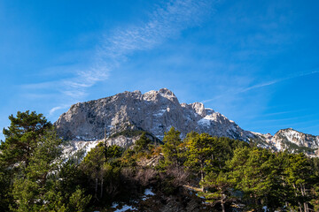 Pedraforca mountain range with rugged peaks bathed in sunlight, contrasting beautifully against a clear blue sky, resembling a perfect day in nature in Catalonia Spain