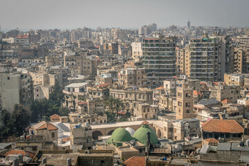 The aerial view of the downtown of Tripoli, the city in northern Lebanon, with the dusty streets, numerous building, residential houses, and Mediterranean sea.  © Artaxerxes