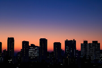 Fototapeta premium a city skyline with the sun setting behind it
