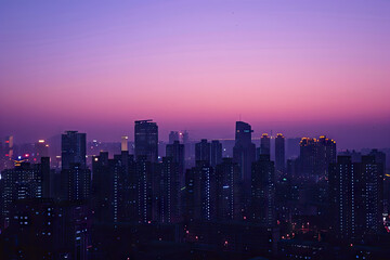 Fototapeta premium a city skyline with the sun setting behind it