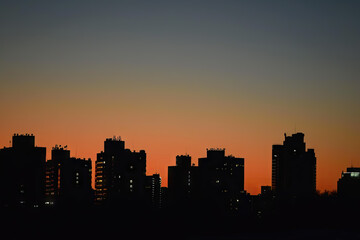 Fototapeta premium a city skyline with the sun setting behind it