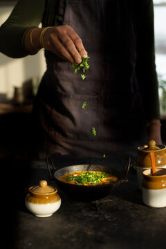 Adding garnish to a curry 