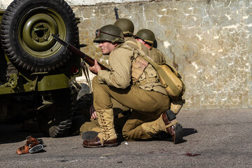 Historical reconstruction. An American infantry soldiers from the World War II  prepare to attack...