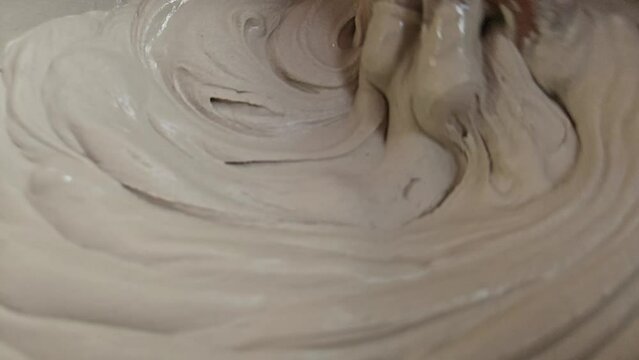 Hand Of An Sculpture Artist Mixing Plaster Of Paris And Water In A Bowl To Make Plaster Mold, India