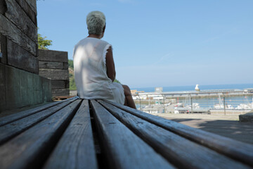 mujer mayor sola pensativa sentada mirando el mar getaria país vasco 4M0A1020-as24