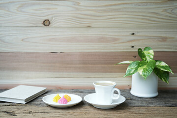 Coffee and dessert and golden pothos plant pot on wooden table