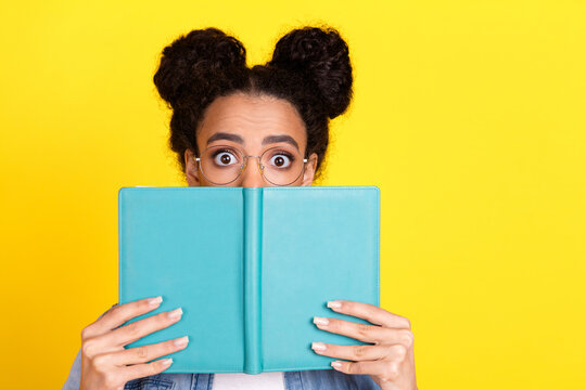 Portrait of nice young girl book cover face wear denim shirt isolated on yellow color background