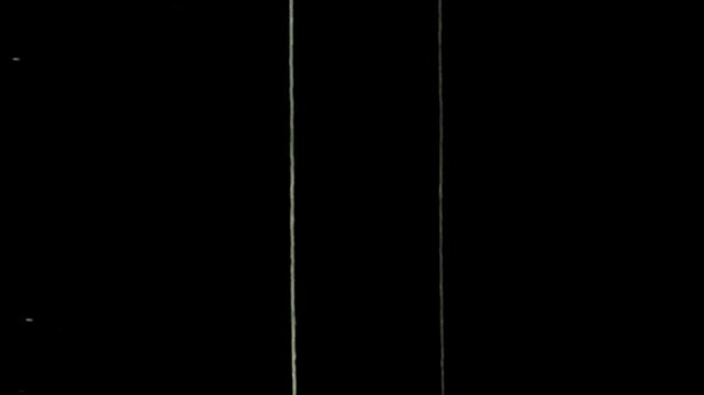 Old film overlay, featuring scratches and damage, is placed on a black background.