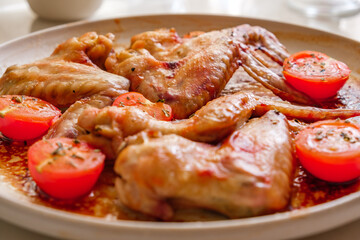 baked chicken wings with tomatoes, selective focus
