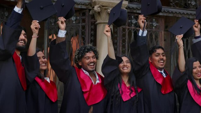 Indian students, wearing traditional academic gown, cap, celebrate academic achievement event.