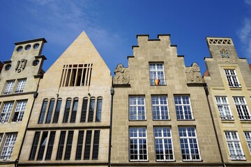 Fototapeta premium Schönes altes Kaufmannshaus und Altbau in Beige und Naturfarben vor blauem Himmel im Sonnenschein am Prinzipalmarkt in der City und Altstadt von Münster in Westfalen im Münsterland