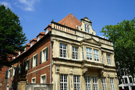 Ehemaliger Heeremannscher Hof mit alter Architektur und sch&ouml;ner Fassade in Beige und Naturfarben vor blauem Himmel im Sonnenschein in der K&ouml;nigsstra&szlig;e in der Altstadt von M&uuml;nster im M&uuml;nsterland