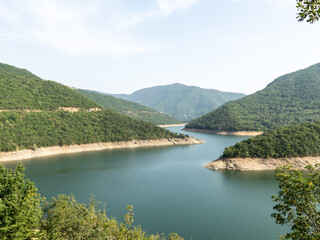Beautiful lake surrounded by lush green mountains on a sunny day